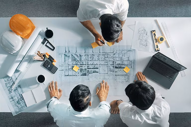 Equipo de ingeniería revisando los planos de un proyecto de climatización